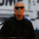 John Carpenter wearing sunglasses during a live screening of his famous "They Live" film.